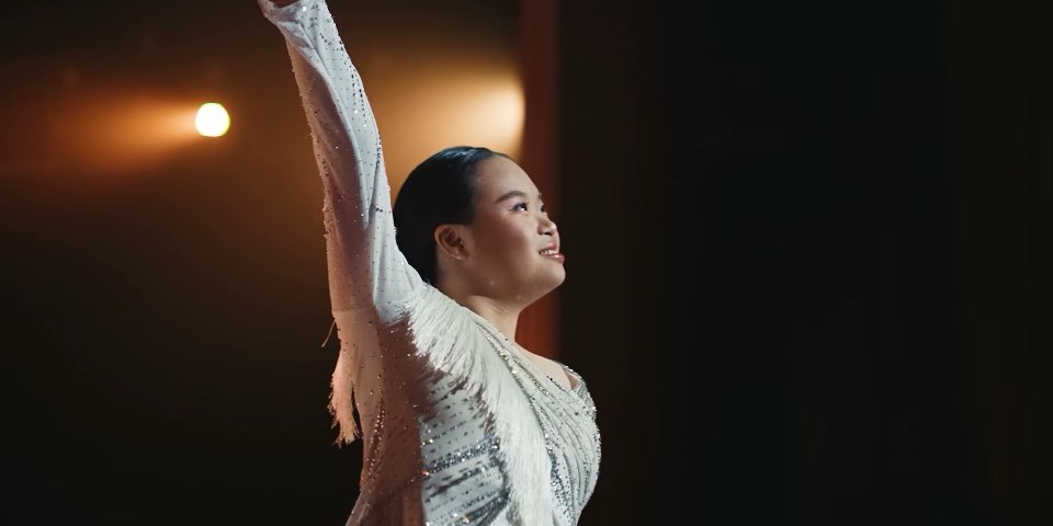 Megan Tang dancing on stage under a spotlight in Income's "For Every Story" film, 2026
